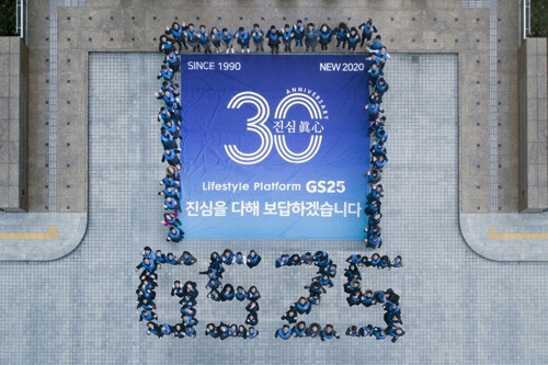 서울 역삼동 GS타워에서 GS25임직원들이 모여 기념 현수막과 GS25 글자를 만들며 기념사진을 찍은 모습. GS리테일 제공